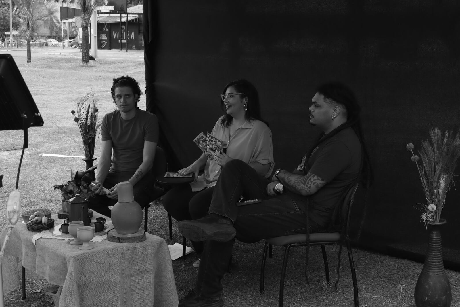 Roda de conversa cultural ao ar livre, em preto e branco